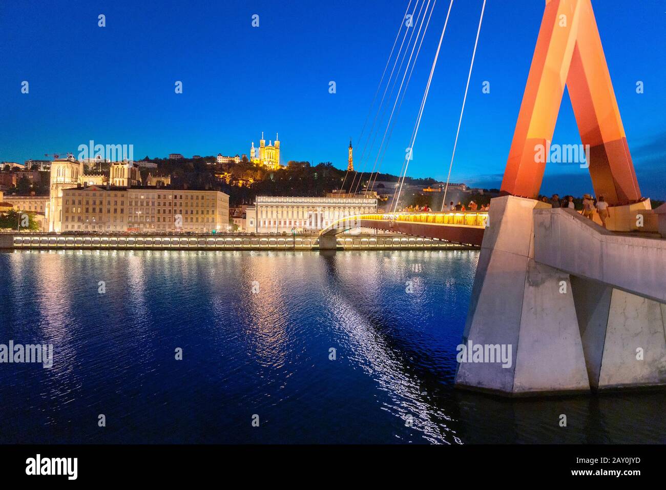 23. Juli 2019, Lyon, Frankreich: Stadtbild der Nacht von Lyon mit beleuchtetem Courthouse und roter Fußgängerbrücke über den Fluss Saone. Panorama-Blau-Stundenlandschaft Stockfoto
