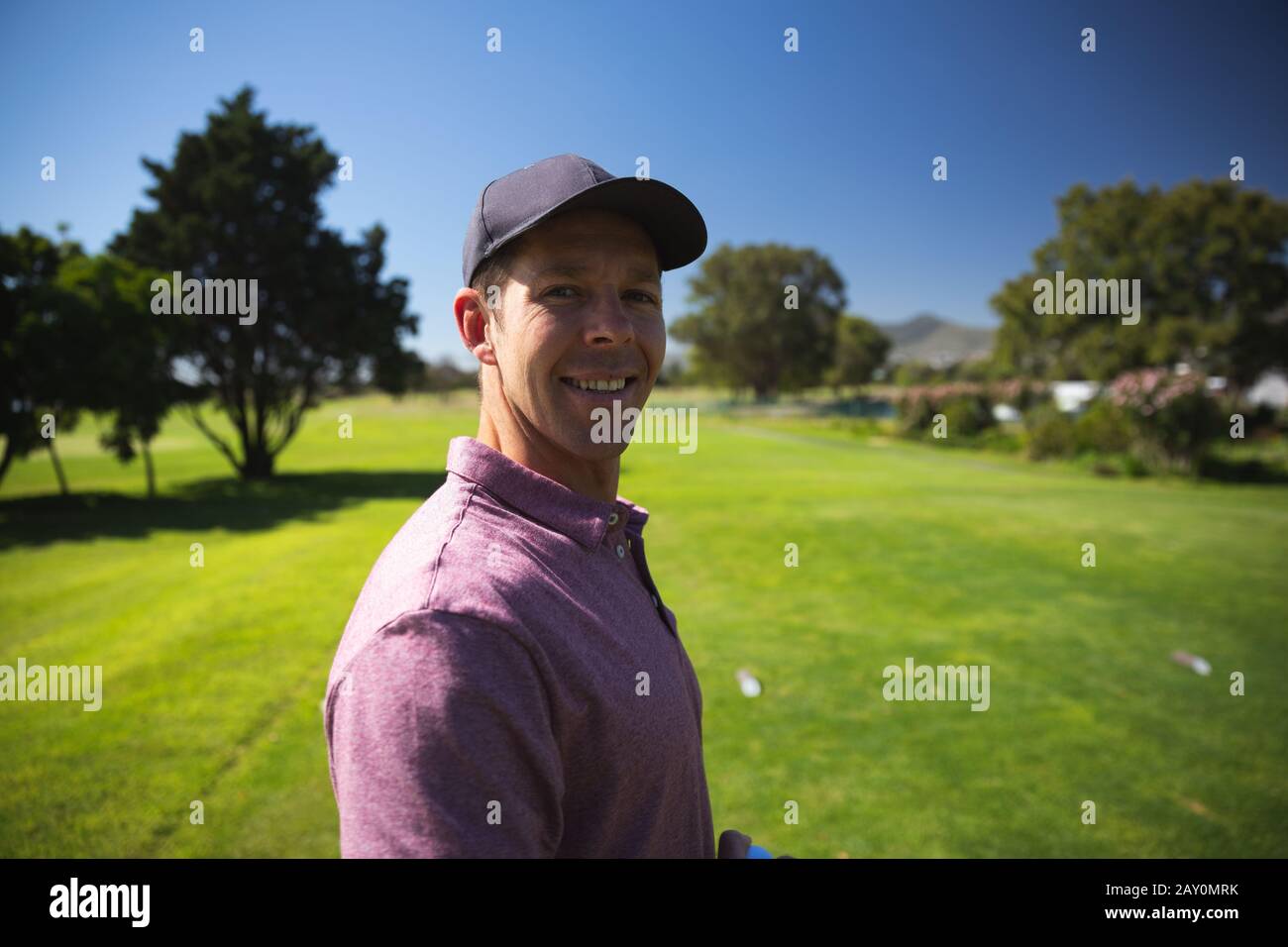Golfer lächelnd und mit Blick auf die Kamera Stockfoto
