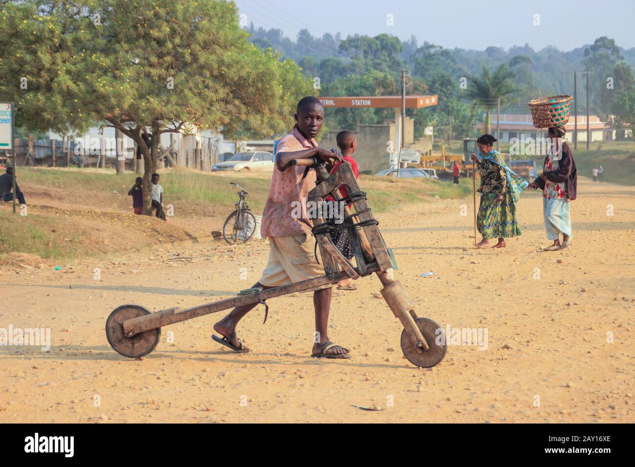 Kampala, Uganda - 31. Januar 2015: Hausgemachte Holz-Kinderroller werden für den Transport von Waren von Kindern in Afrika verwendet. Arme afrikanische Kindheit und Chi Stockfoto