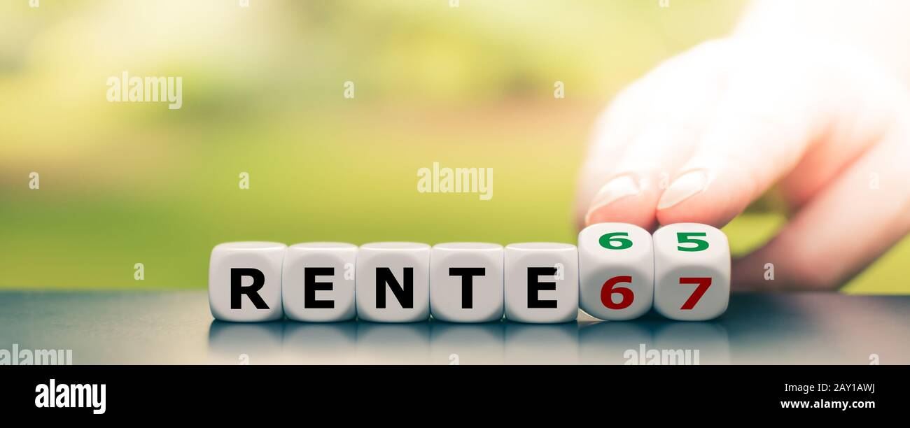 Hand dreht Würfel und ändert den deutschen Ausdruck "Rente 67" ("Rente 67") in "Rente 65" ("Rente 65"). Stockfoto