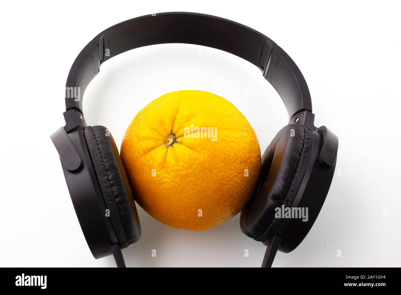 Orange in schwarzen Kopfhörern auf weißem Hintergrund. Stockfoto
