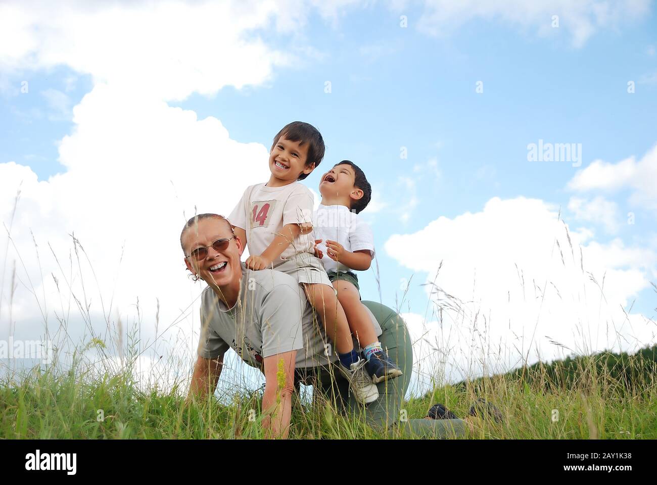 Zwei Kinder auf der Rückseite ihrer Mutter Stockfoto