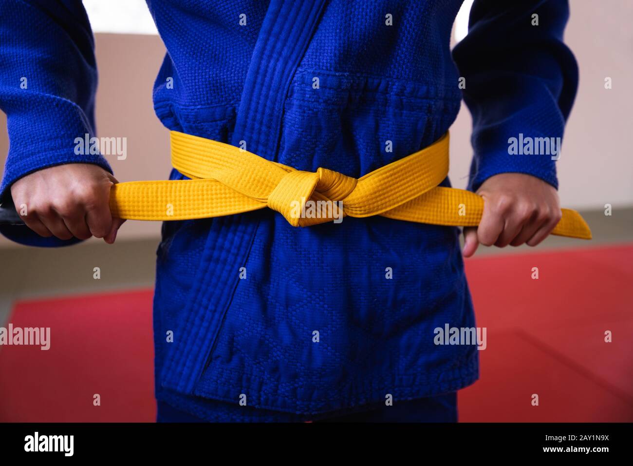 Judoka legt den gelben Gürtel an Stockfoto