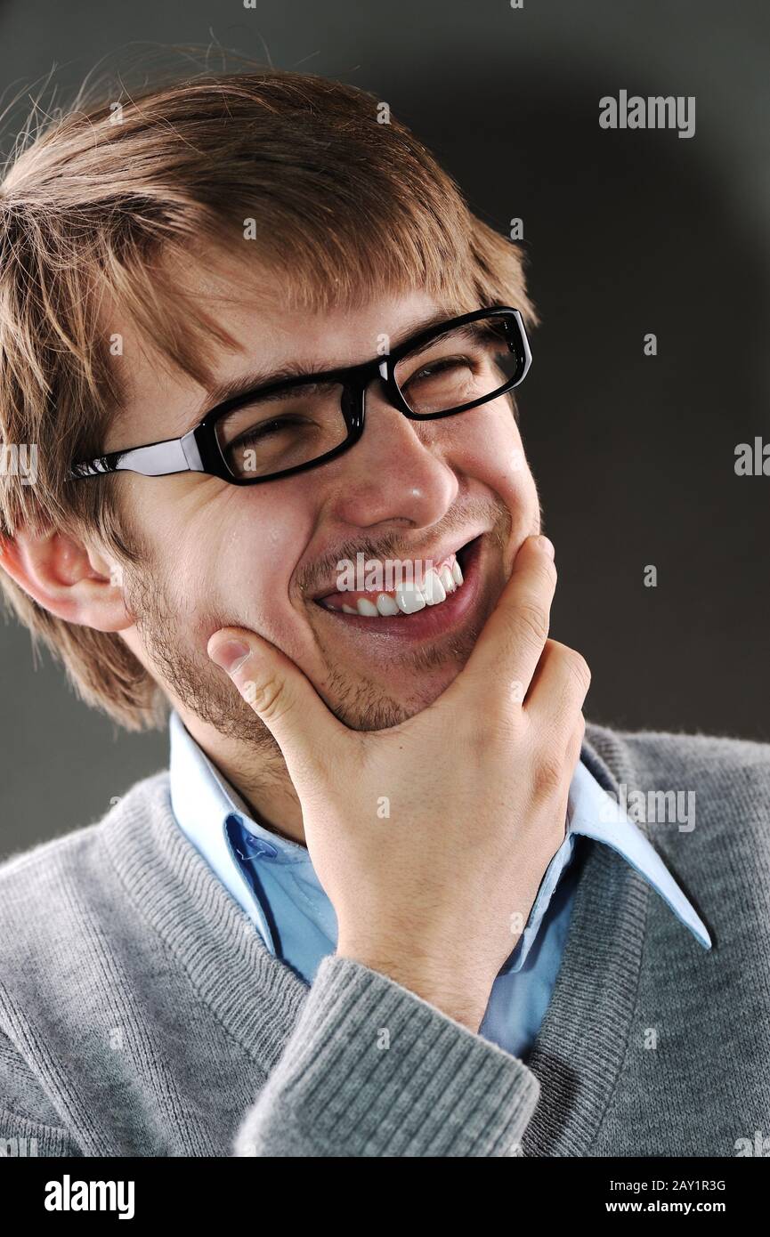 Junger kaukasischer Mann mit Brille lachend Stockfoto