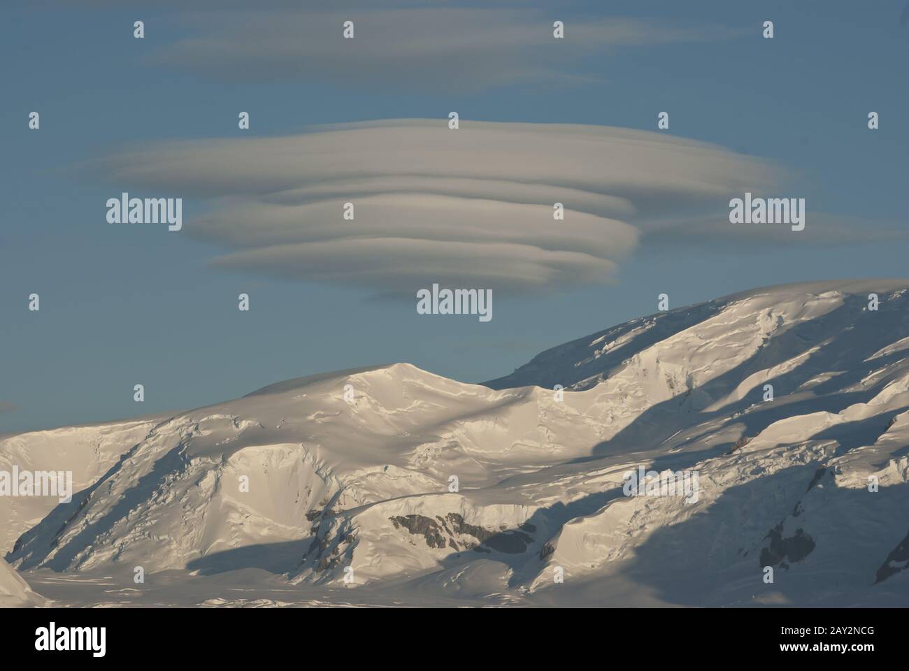 Ungewöhnliche UFO-förmige Wolke über den antarktischen Bergen im Wintertag. Stockfoto