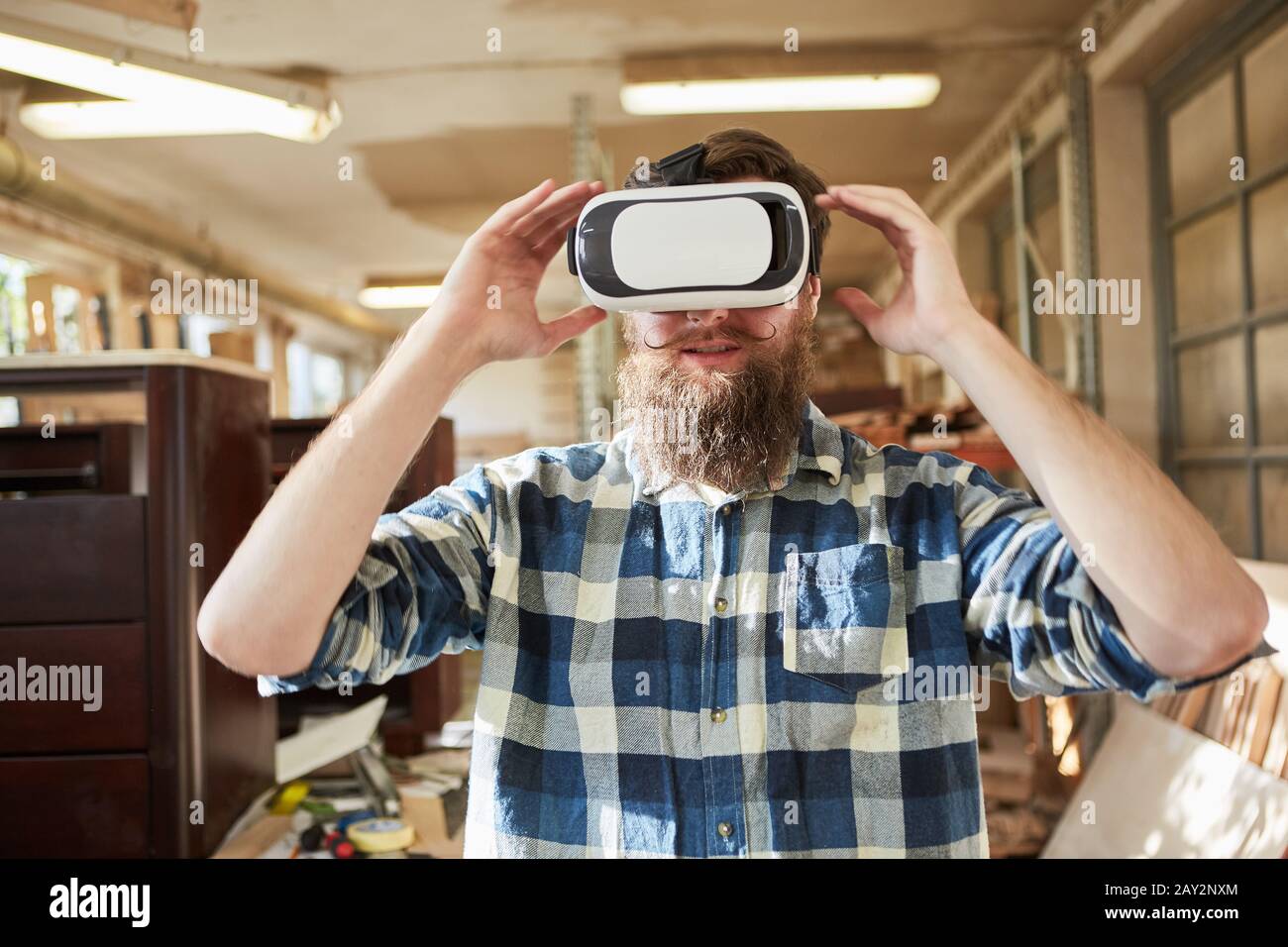 Handwerker als Möbelhersteller mit VR-Brille zur Visualisierung und Planung Stockfoto