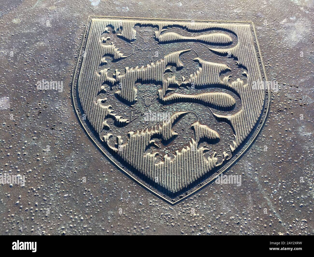 Es ist ein Foto des normand-Wappens oder Wappens auf dem Boden auf der Straße oder auf dem Bürgersteig. Es hat die 2 Löwen oder Leoparden Formen Stockfoto