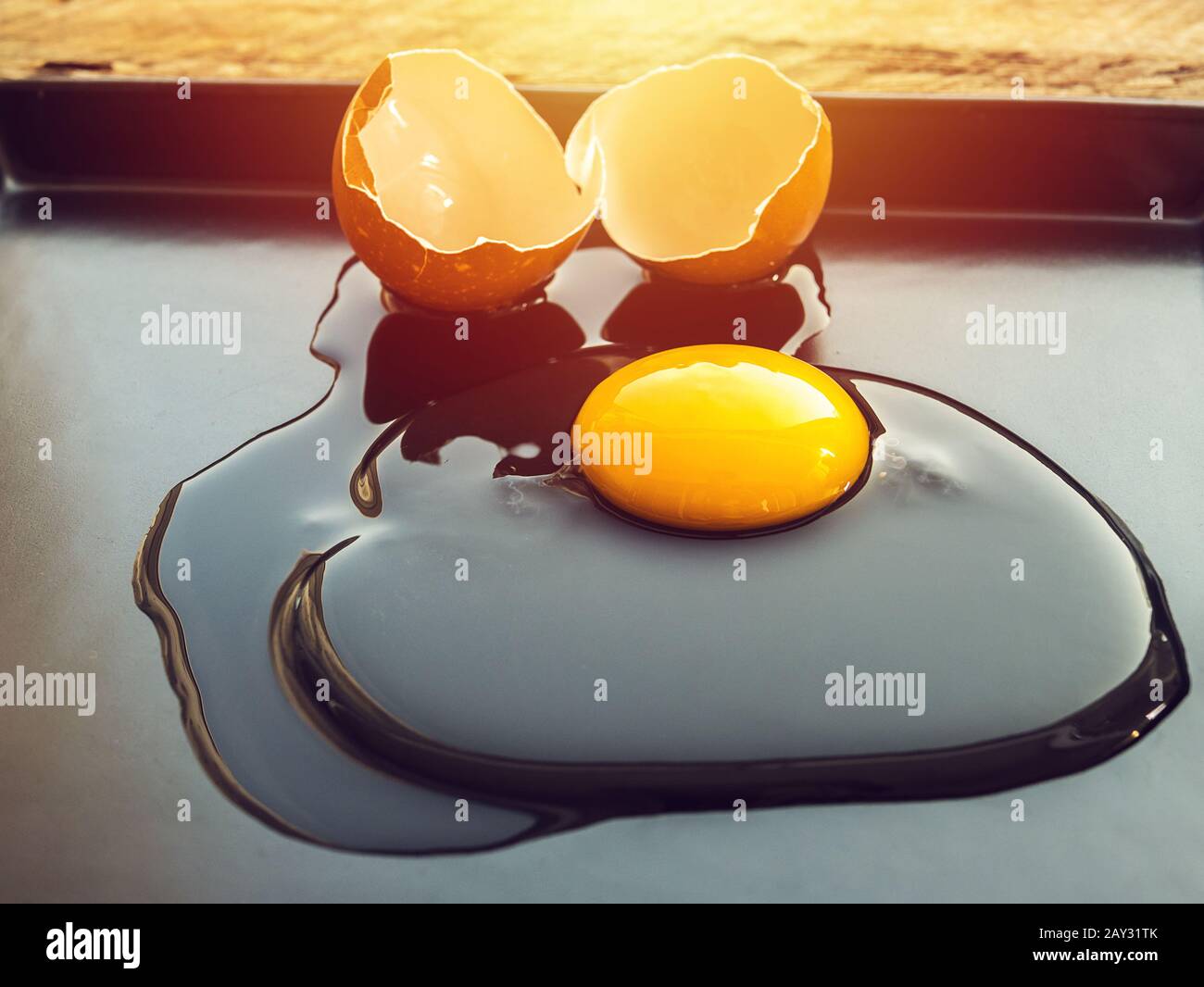 Zerbrochenes Henne-Ei auf schwarzem Gericht mit Morgenlicht Stockfoto