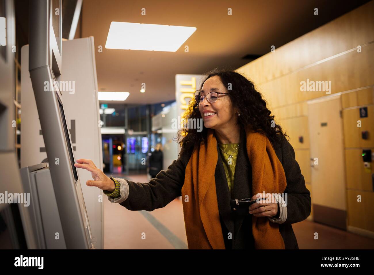 Frau kauft Tickets im Ticketautomaten Stockfoto