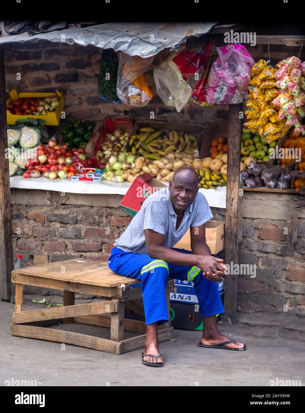 Johannesburg, Südafrika, 4. Oktober - 2019: Der Mann sitzt neben seinem Obst- und Gemüsestall im Township. Stockfoto
