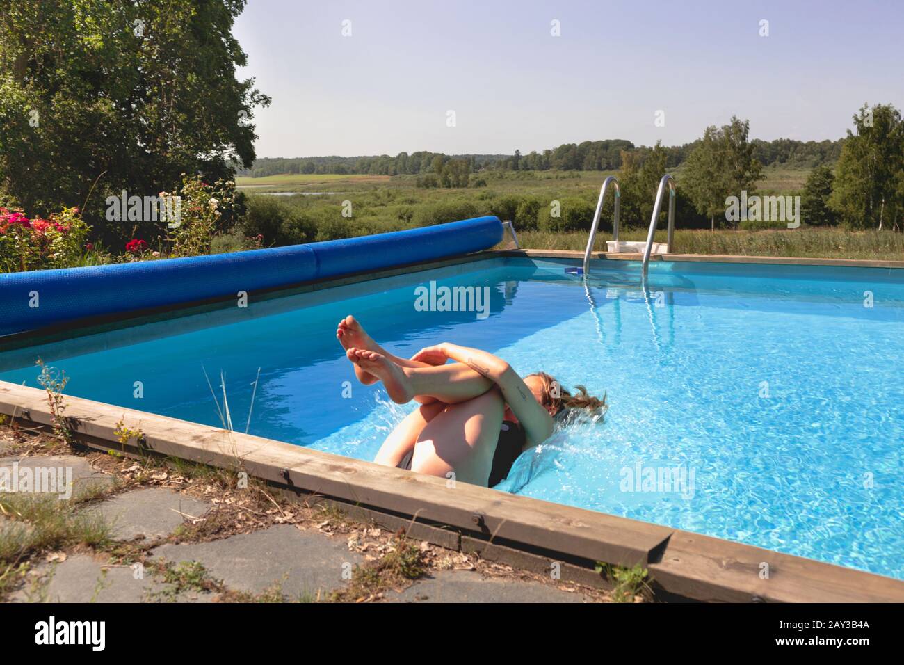 Frau springt ins Schwimmbad Stockfoto