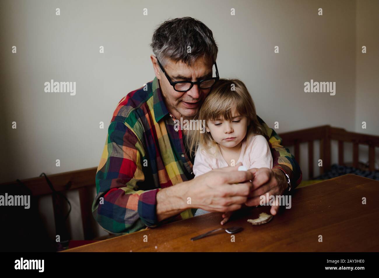 Großvater mit Enkelin am Tisch Stockfoto