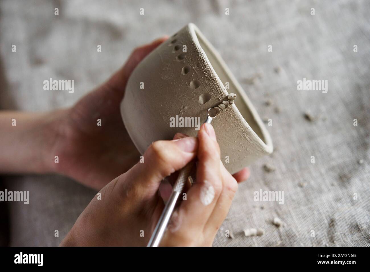 Weibliche Hände halten eine Schüssel für das Gießen von Ton-Produkte Stockfoto