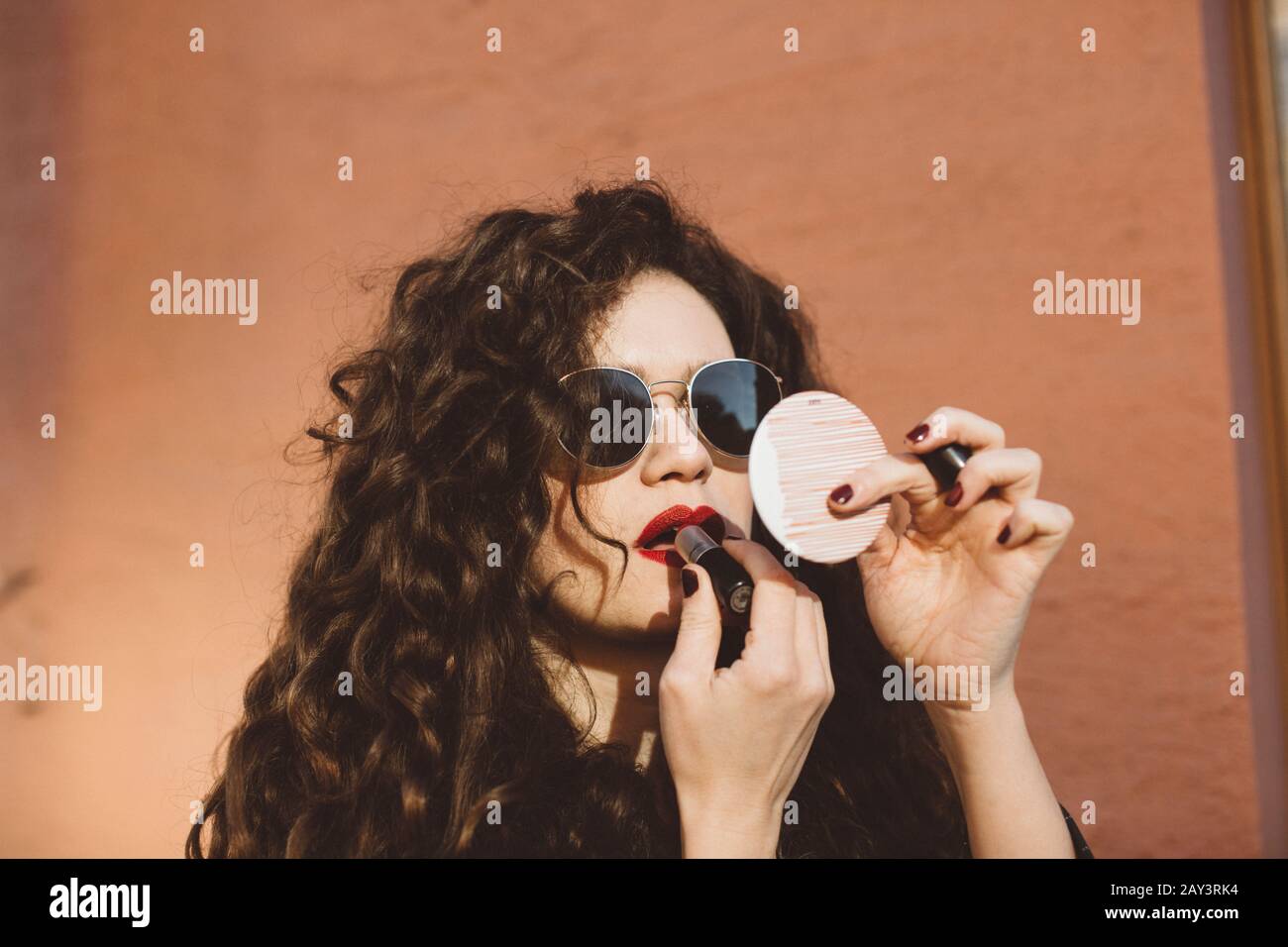 Frau Auftragen von Lippenstift Stockfoto