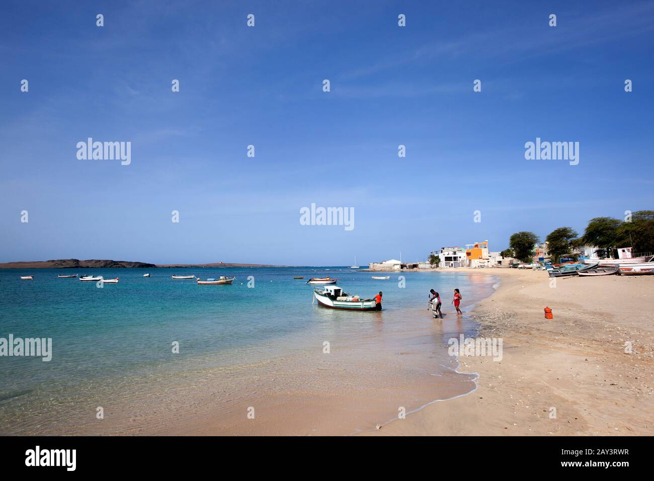 SAL Rei, Kap Verde - 28. Januar 2020: Menschen mit Außenbordmotor in der Nähe eines traditionellen Fischerbootes am Strand von Sal Rei auf der Insel Boa Stockfoto