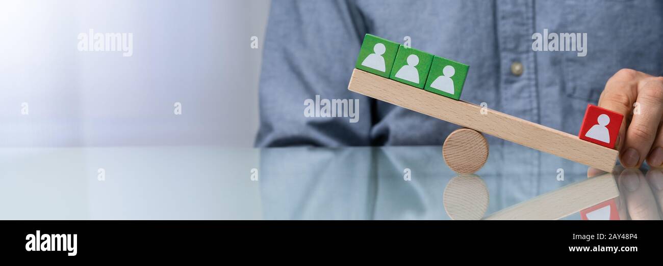 Hand Balancing Pawns der Person Auf Wooden Seesaw Stockfoto