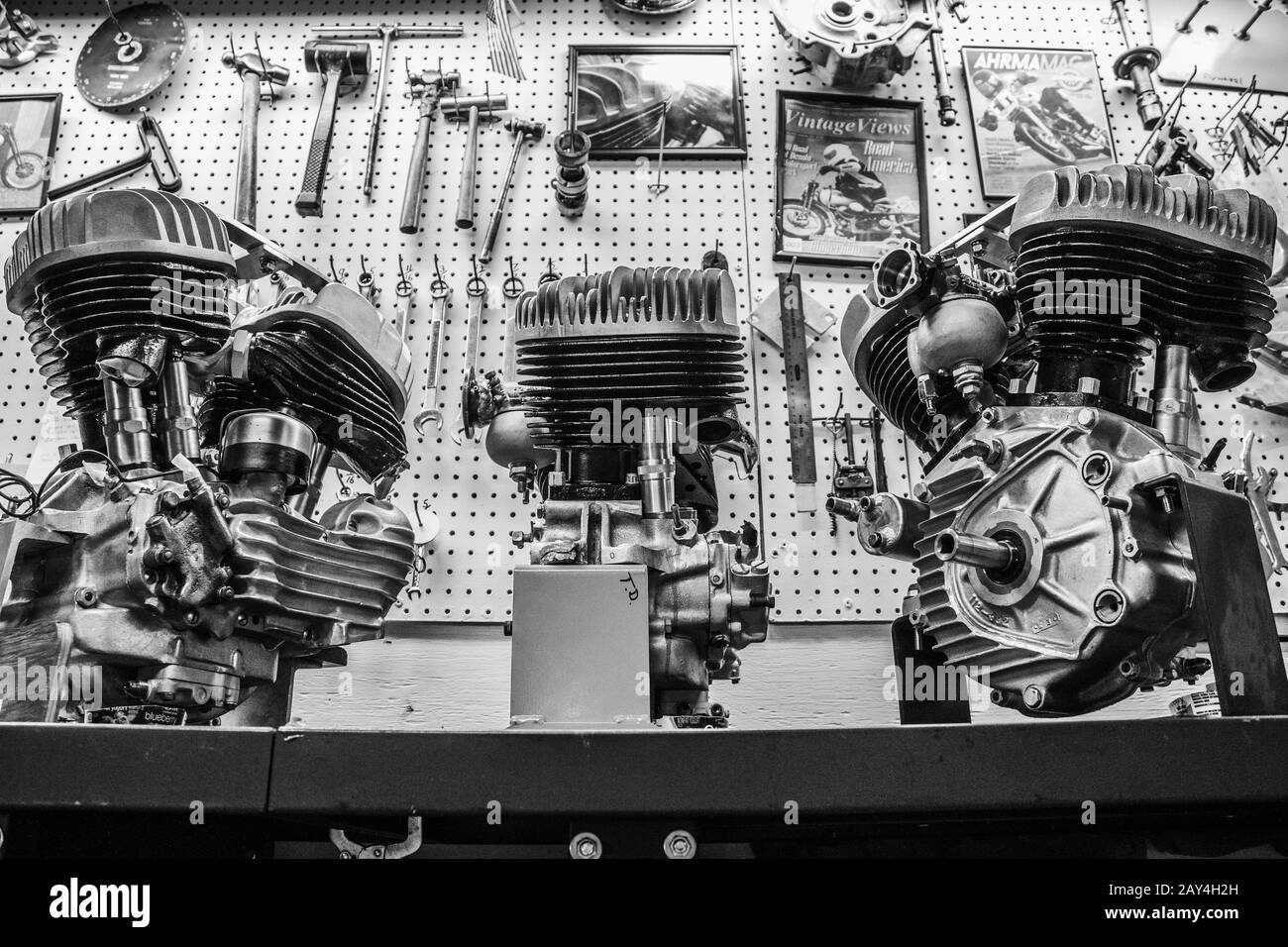 Drei alte harley davidson Motoren sind in einer Motorradwerkstatt ausgestellt. Stockfoto