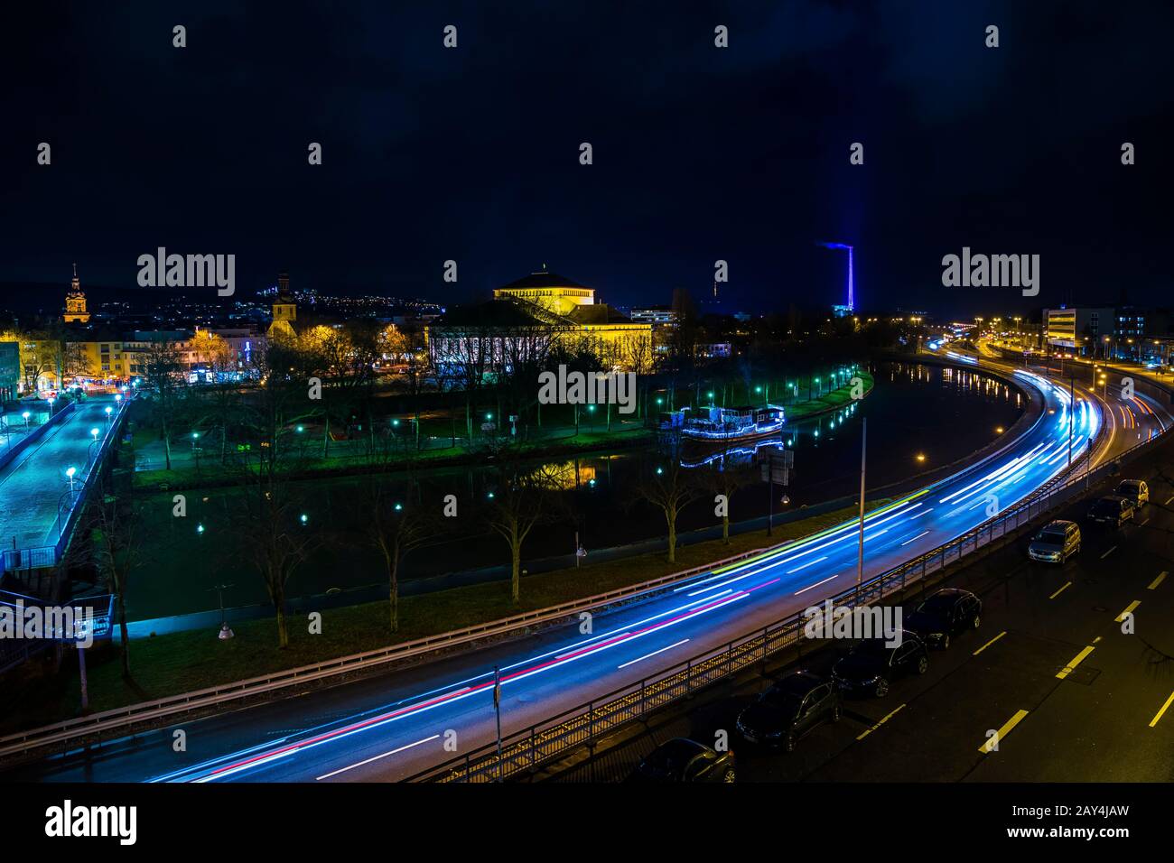 Deutschland, Zauberhafter Nachthimmel über Dächern und belebte Autobahnstraße der Innenstadt von saarbrucken Stadt bei Nacht mit Wolken, viel Verkehr und Sternenhimmel Stockfoto