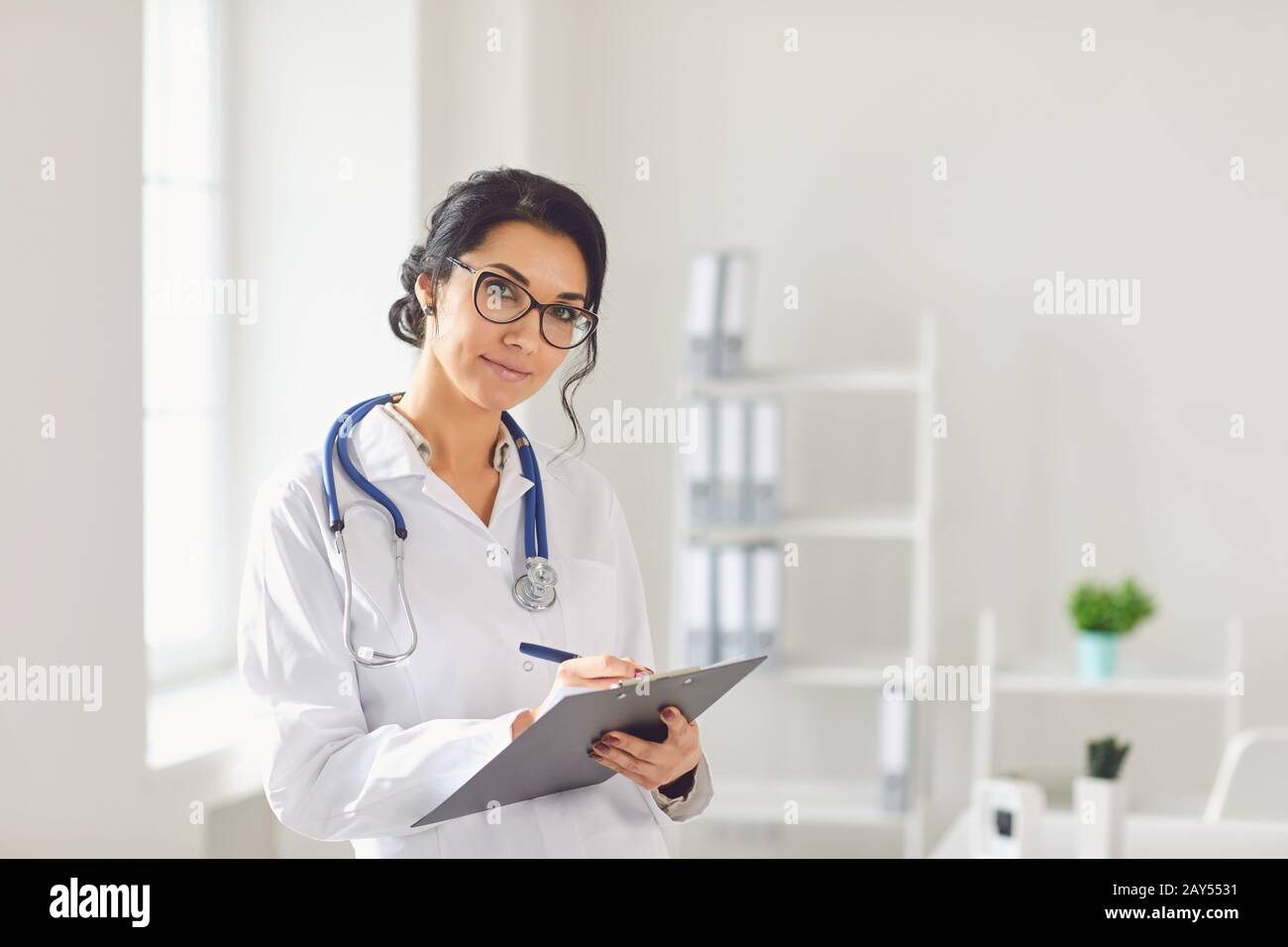 Frau Ärztin Kinderärztin steht im weißen Büro des Krankenhauses. Stockfoto