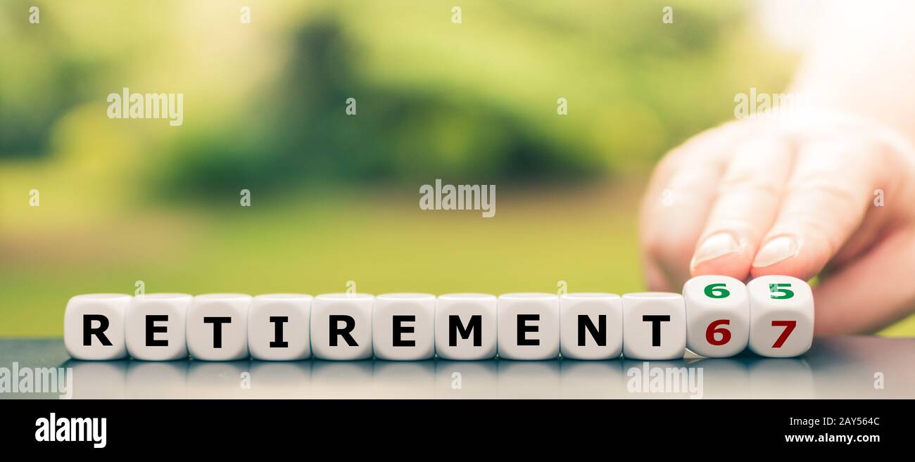 Hand dreht Würfel und ändert den Ausdruck "67" in "65". Stockfoto