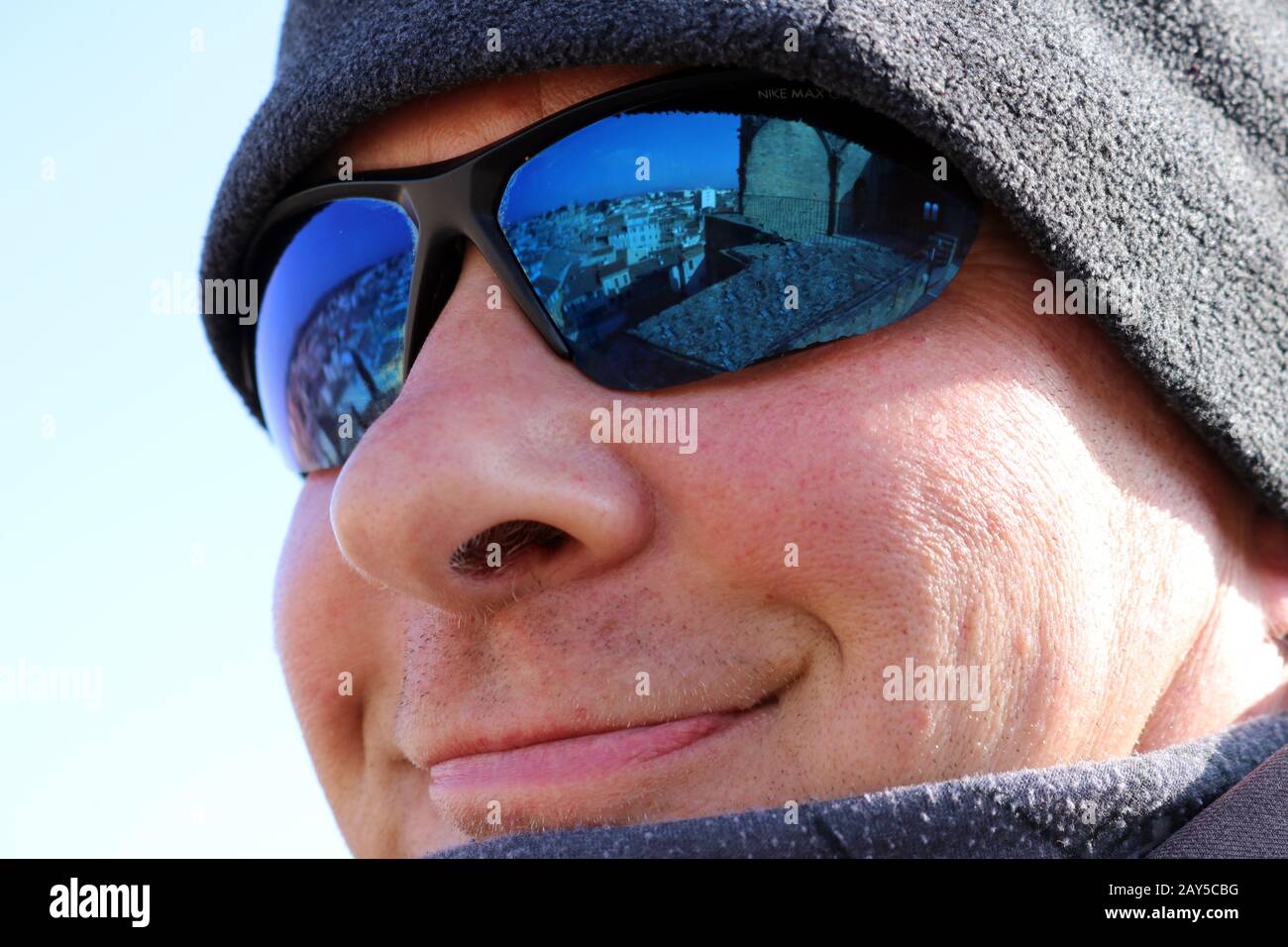 Nahaufnahme des Gesichts eines lächelnden Mannes mit Sonnenbrille und Hut Stockfoto
