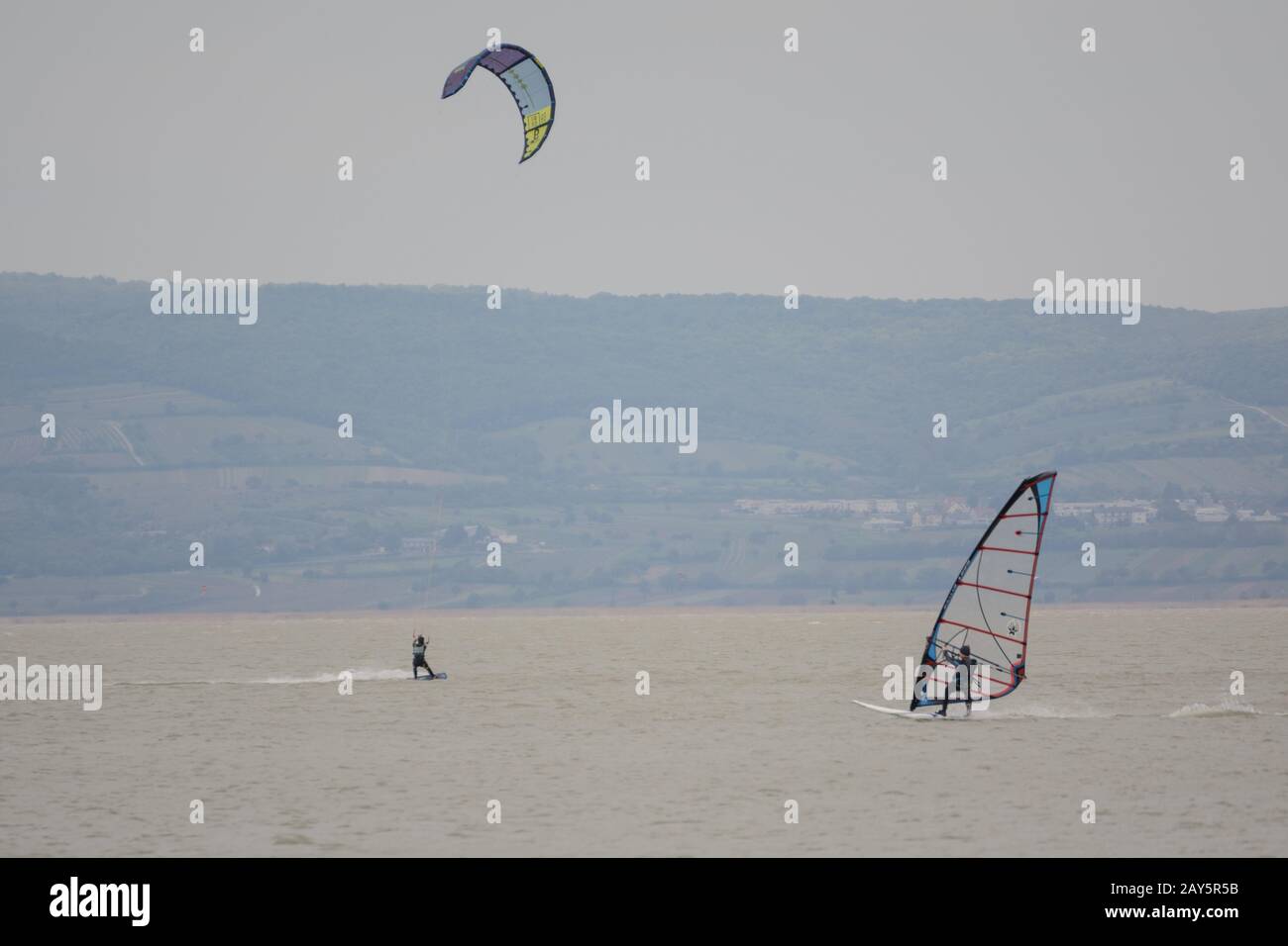 Surfen in verschiedenen Formen - Kitesurfing und Windsurfen am Neusiedler See Stockfoto