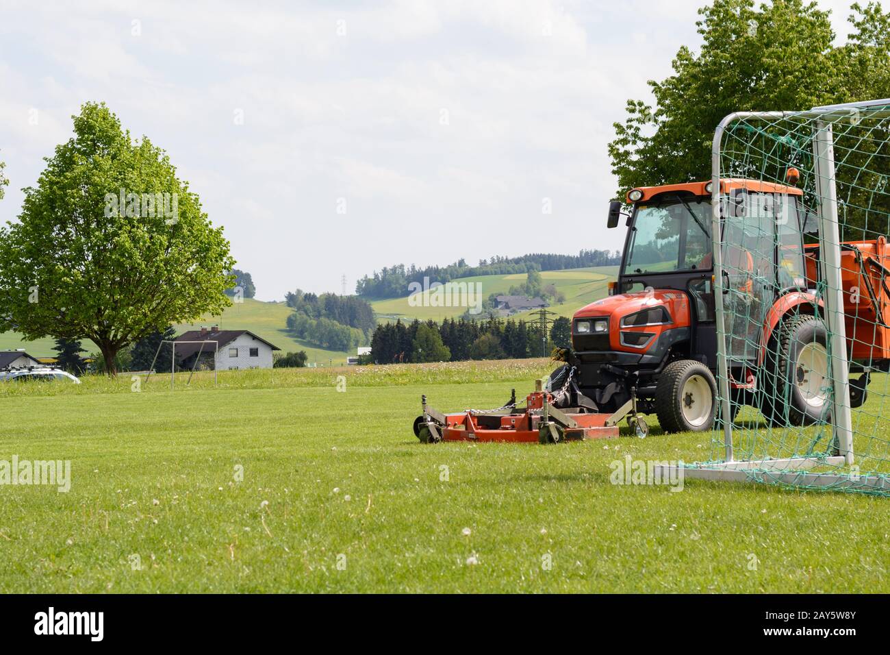 Echtes Gras auf dem Sportgelände wird mit einem Rasentraktor gemäht Stockfoto