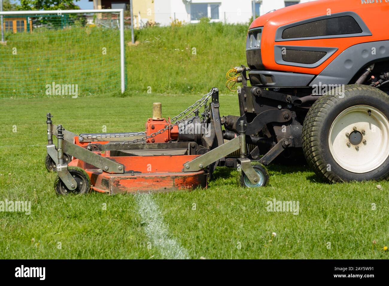 Gras auf dem Fußballfeld wird mit einem Rasentraktor geschnitten Stockfoto
