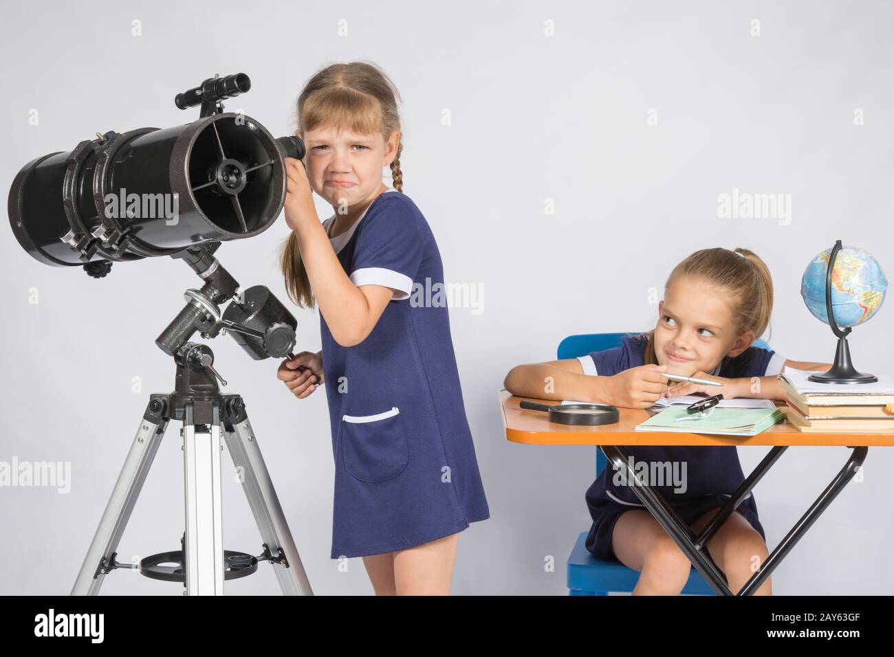 Das Mädchen war verärgert, dass er nicht in das Teleskop, das andere Mädchen, die ihr Spott sah Stockfoto