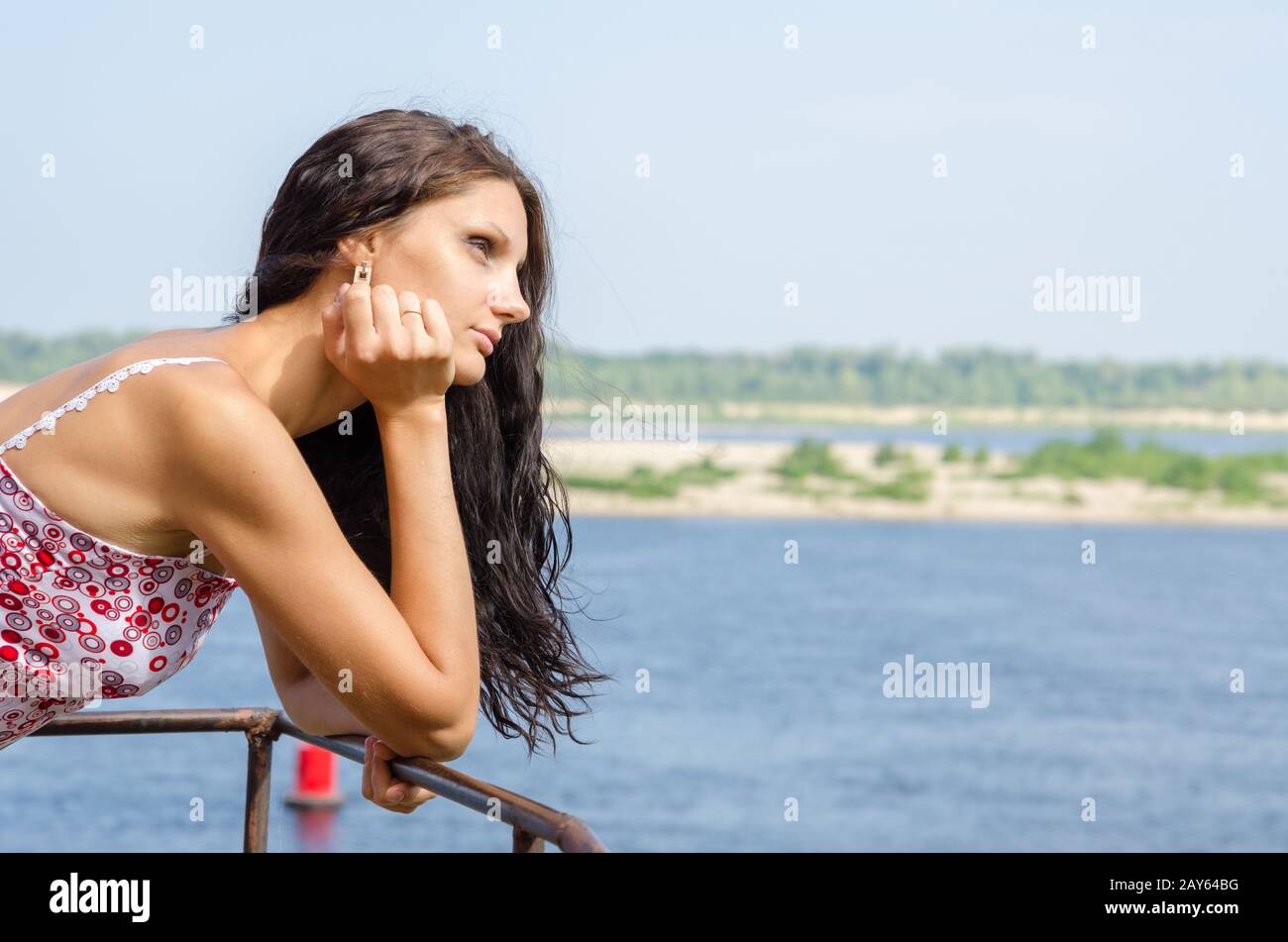 Junge Brünette Mädchen suchen nachdenklich in die Ferne auf dem Hintergrund des Flusses Stockfoto