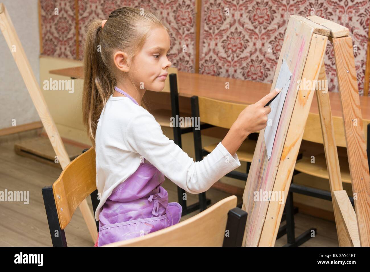 Mädchen-Künstler mit einem Lächeln sehen auf dem Bild auf der Zeichnung Lektion Stockfoto