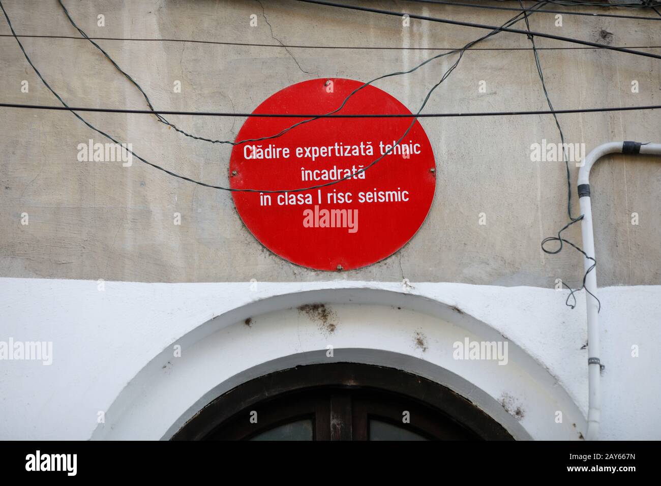Bukarest, Rumänien - 12. Februar 2020: Warnschild an einem alten Gebäude in rumänischer Sprache, dass das seismische Risiko des Gebäudes maximal ist. Stockfoto