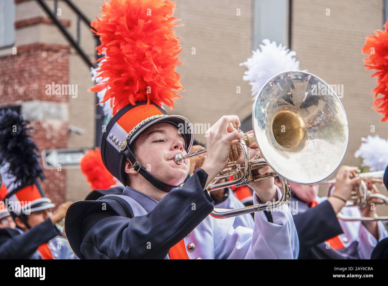 8-28-2019 Tahlequah USA - Junger Mann in Uniform spielt begeistert die Posaune in einer High-School-Marching Band-Parade mit anderen Bandmitgliedern blurr Stockfoto
