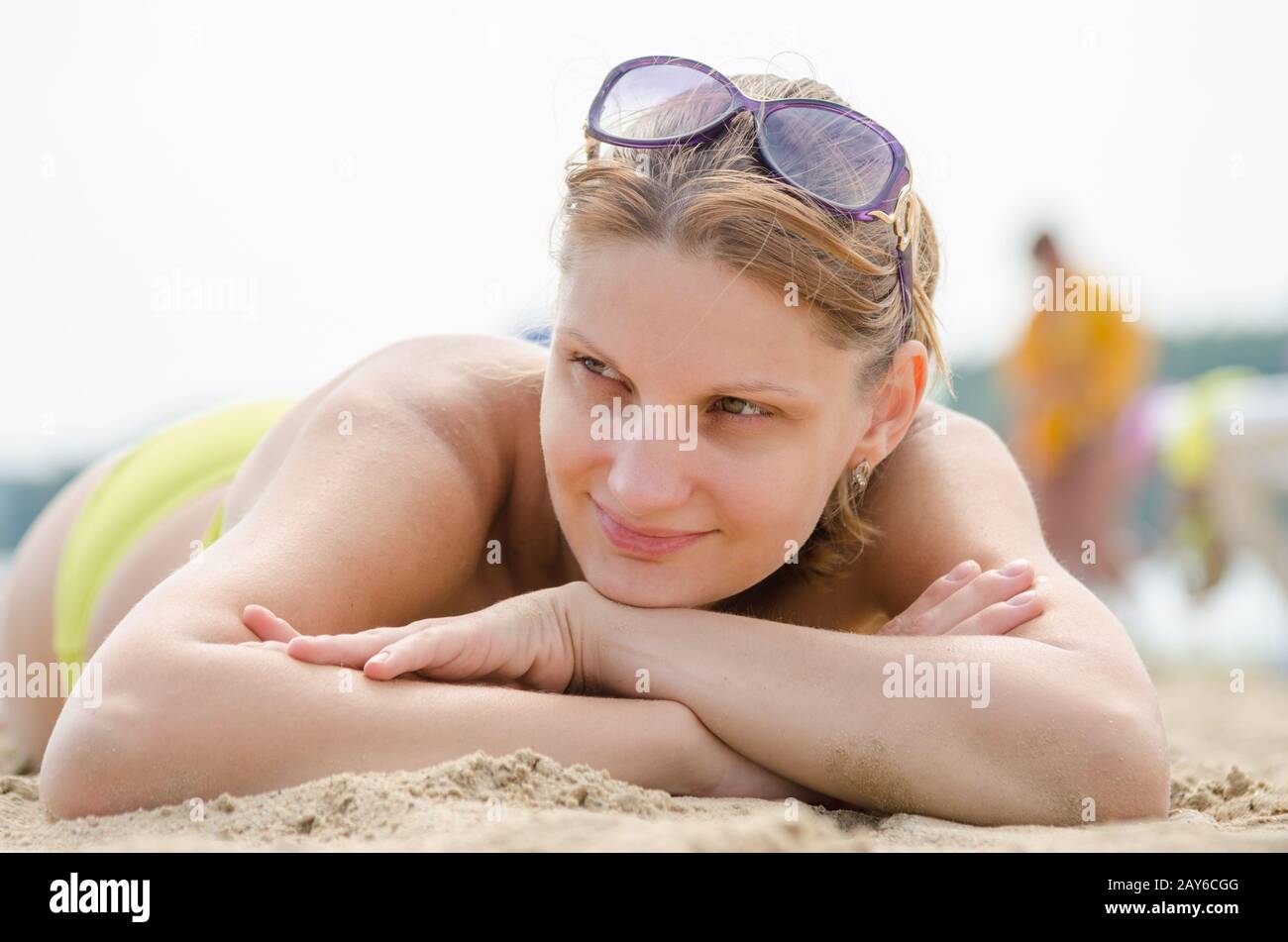 Junges Mädchen am Sandstrand liegen und Blick auf die Seite Stockfoto