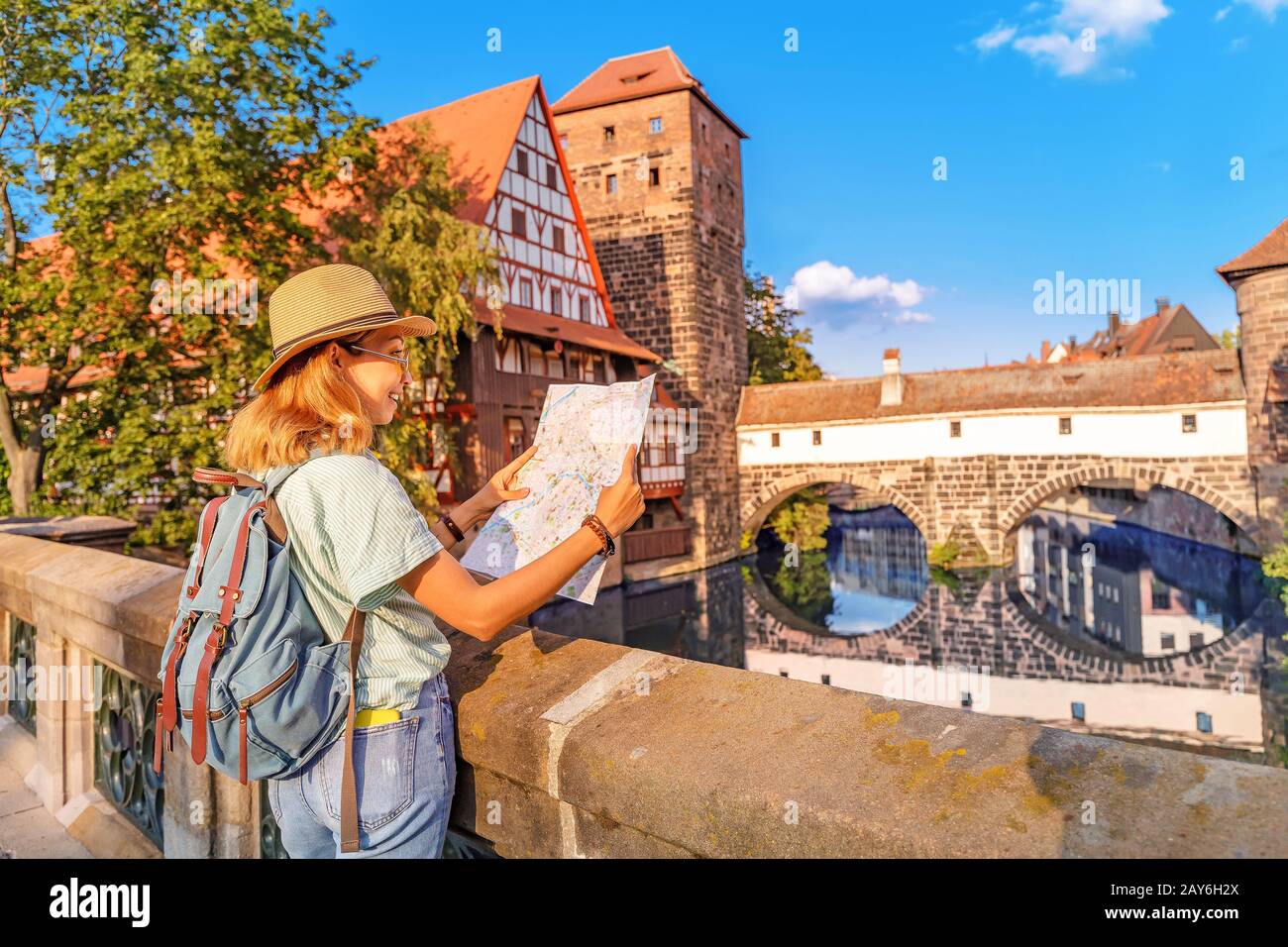 Fröhliche asien-reisender mit Karte an der Pegnitz in der Altstadt von Nürnberg. Reiseziele und Touristenattraktionen Stockfoto