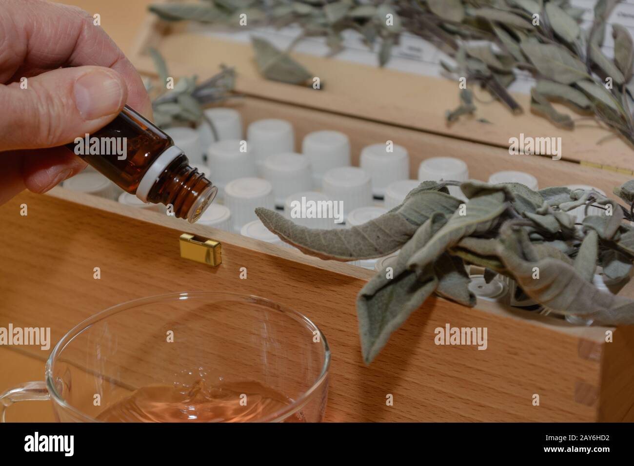 Braune Arzneiflasche über Flüssigkeit - Salbei und andere Arzneiflaschen im Hintergrund Stockfoto