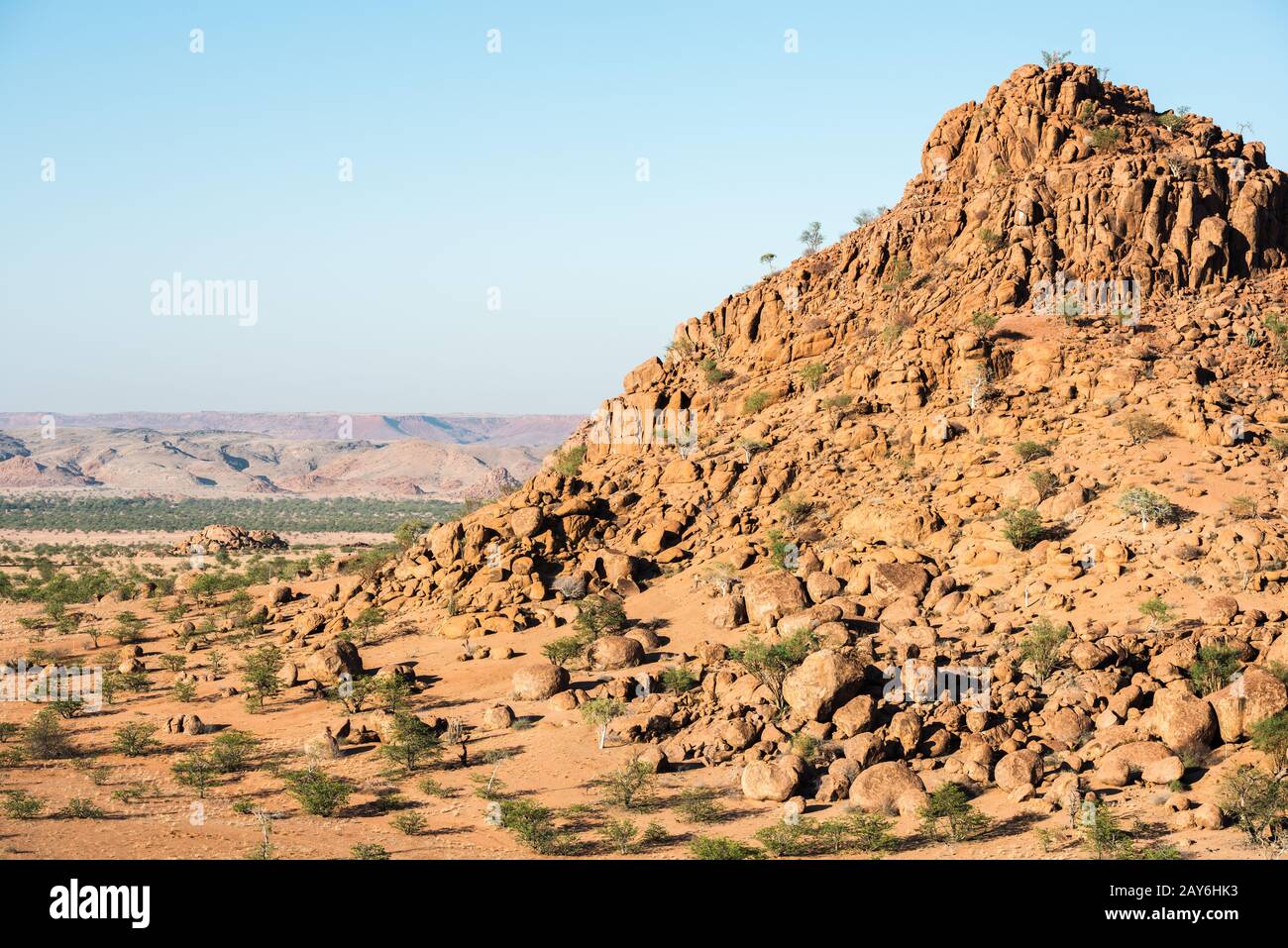 Felsige Landschaft von Namibia mit riesigen Felsbrocken und grünen Bäumen Stockfoto