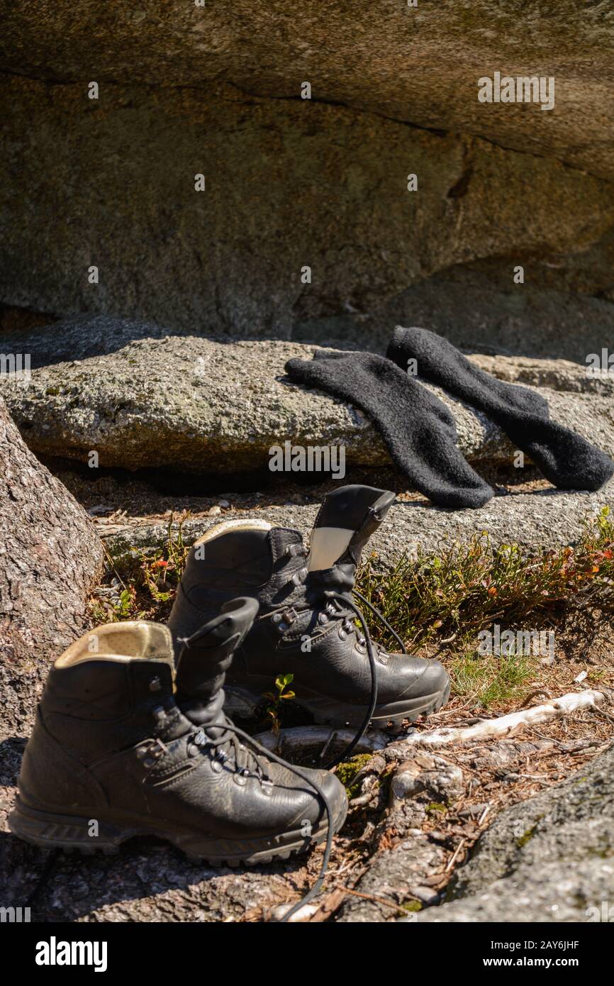Wanderer hat seine Wanderschuhe und Socken am Felsen abgenommen - Erholungspause Stockfoto