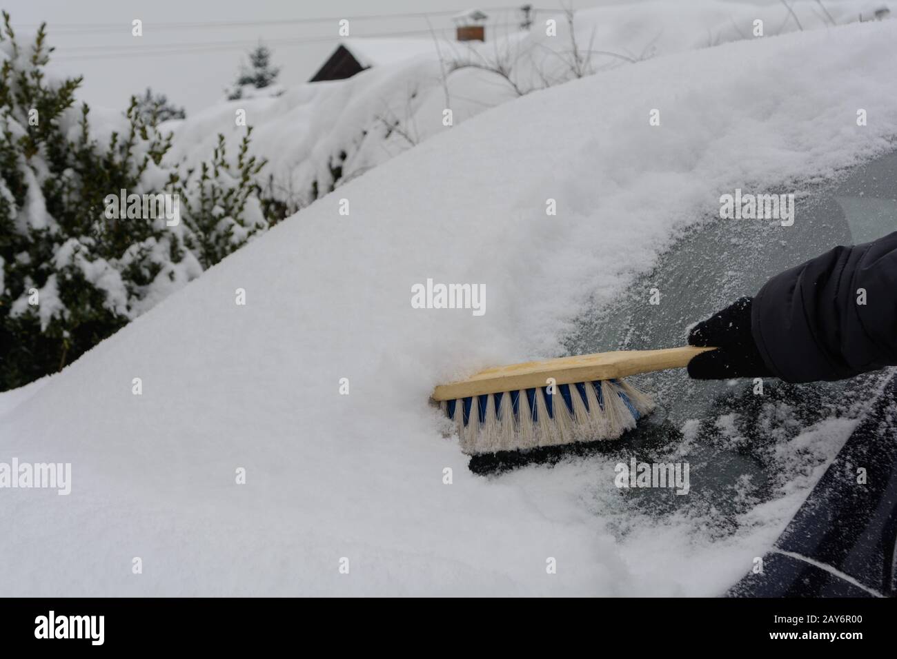 Autofahrer fegen die verschneite Windschutzscheibe mit Augbeater - Nahaufnahme Stockfoto