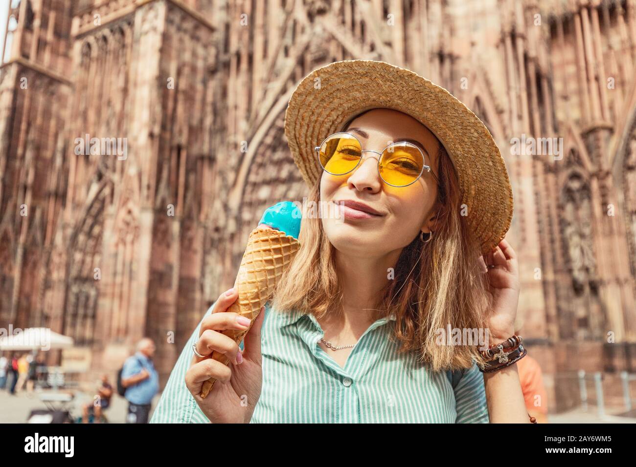 Fröhliches asiatisches Mädchen, das köstliche Eisgelato vor der higen Kathedrale in Europa isst. Lustiges und fröhliches Reisekonzept Stockfoto