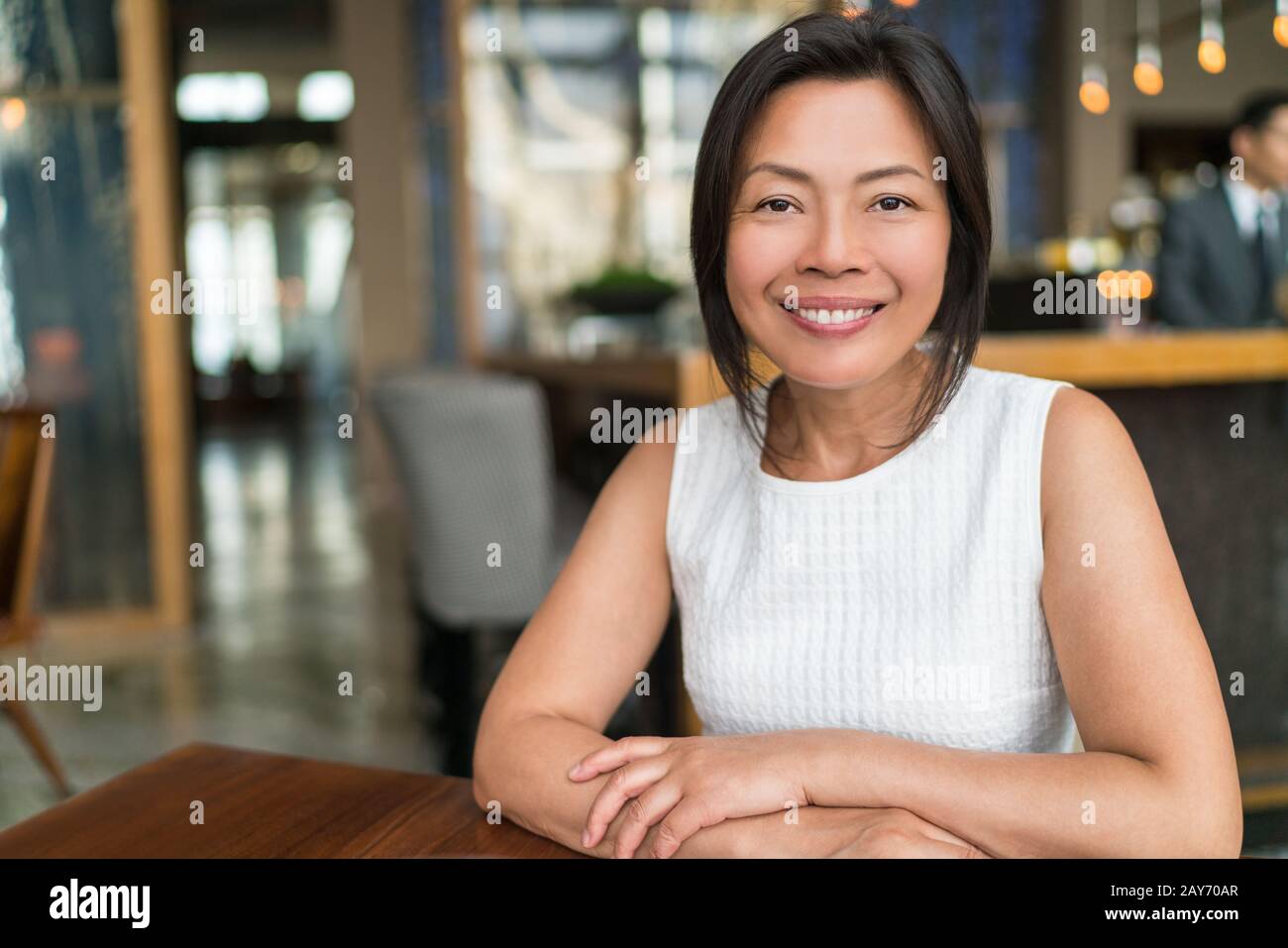Fröhliche elegante asiatische Geschäftsfrau mittleren Alters lächelndes Porträt. Schöne reife chinesische Geschäftsfrau im schicken Restaurant in Shanghai, China. Stockfoto