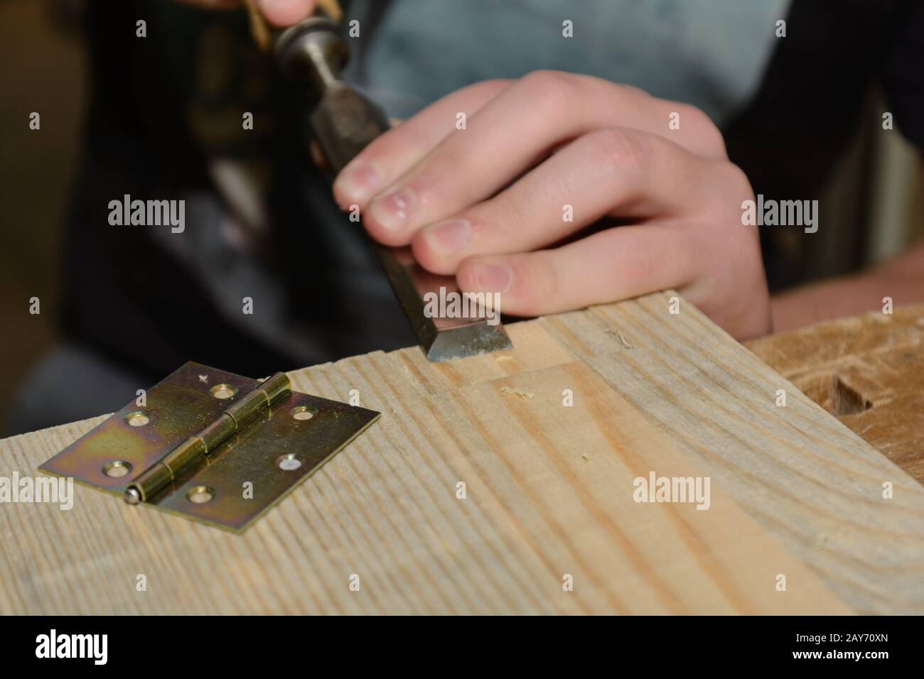 Zimmermann arbeitet Holz mit einem Meißel für ein Scharnier - Nahaufnahme Stockfoto