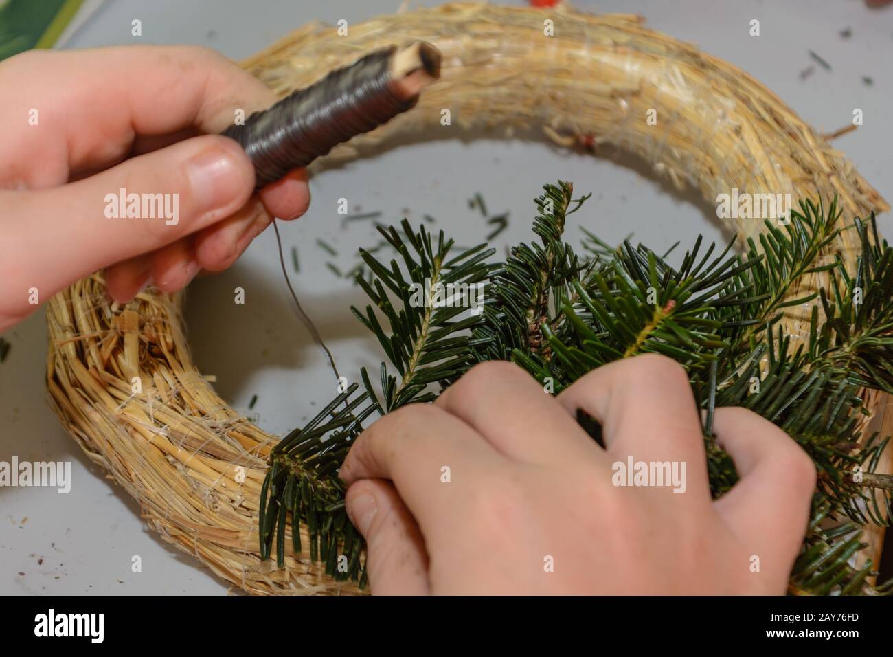 Blumenhändler binden einen Adventskranz - Nahaufnahme der Weihnachtssymbole Stockfoto