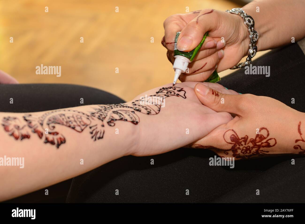 Person macht Henna Tätowierungen an Händen - Nahaufnahme Stockfoto