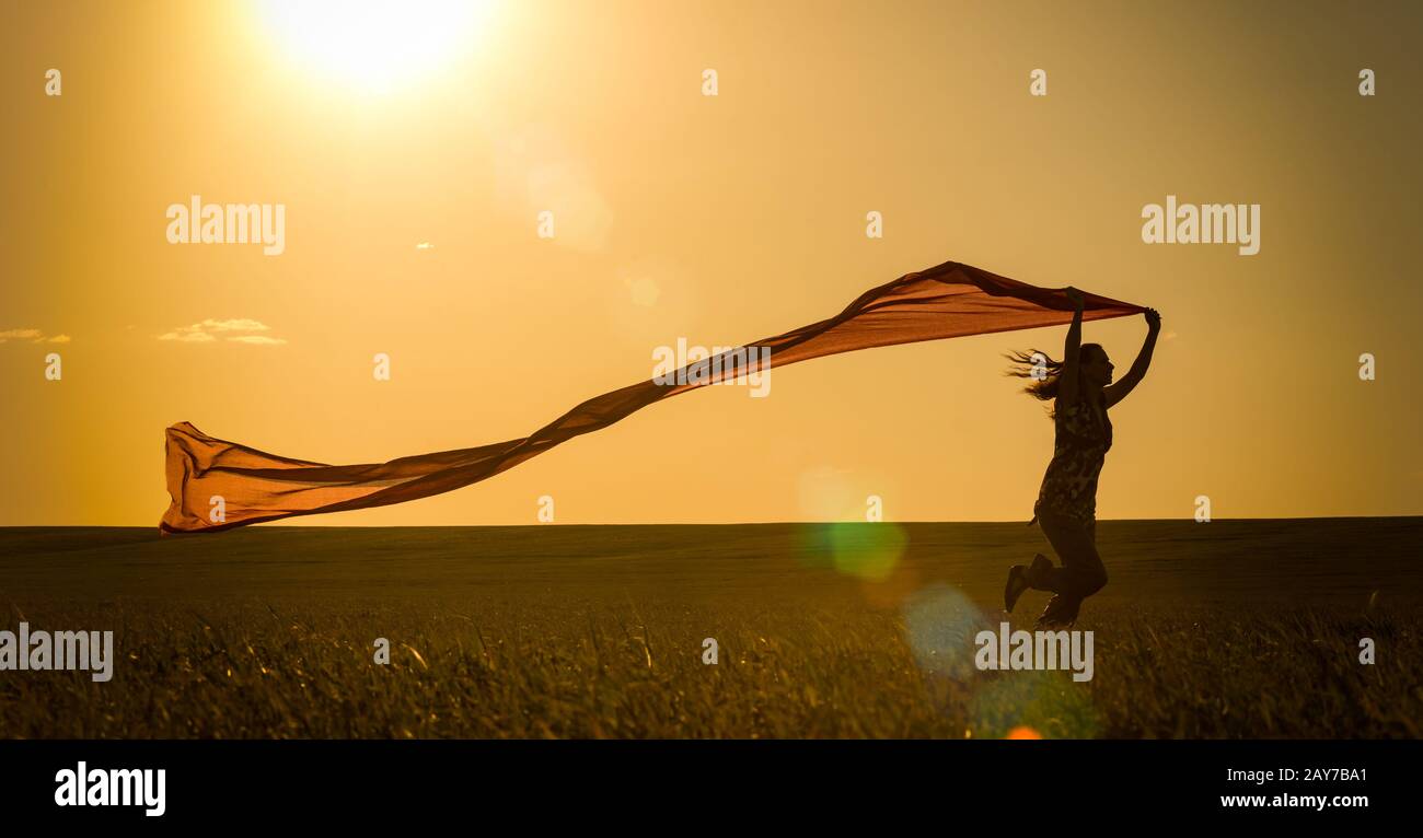 Junge Frau auf einer Landstraße bei Sonnenuntergang im Sommer Feld. Lifestyle Sport Freiheit Hintergrund Stockfoto