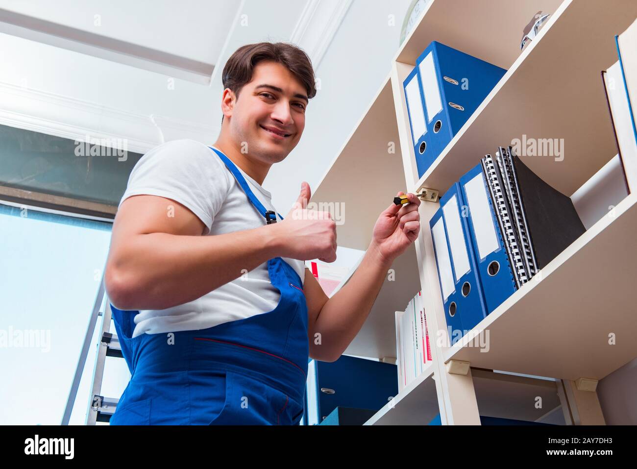 Männliche Büroreinigung Reiniger Regale im Büro Stockfoto