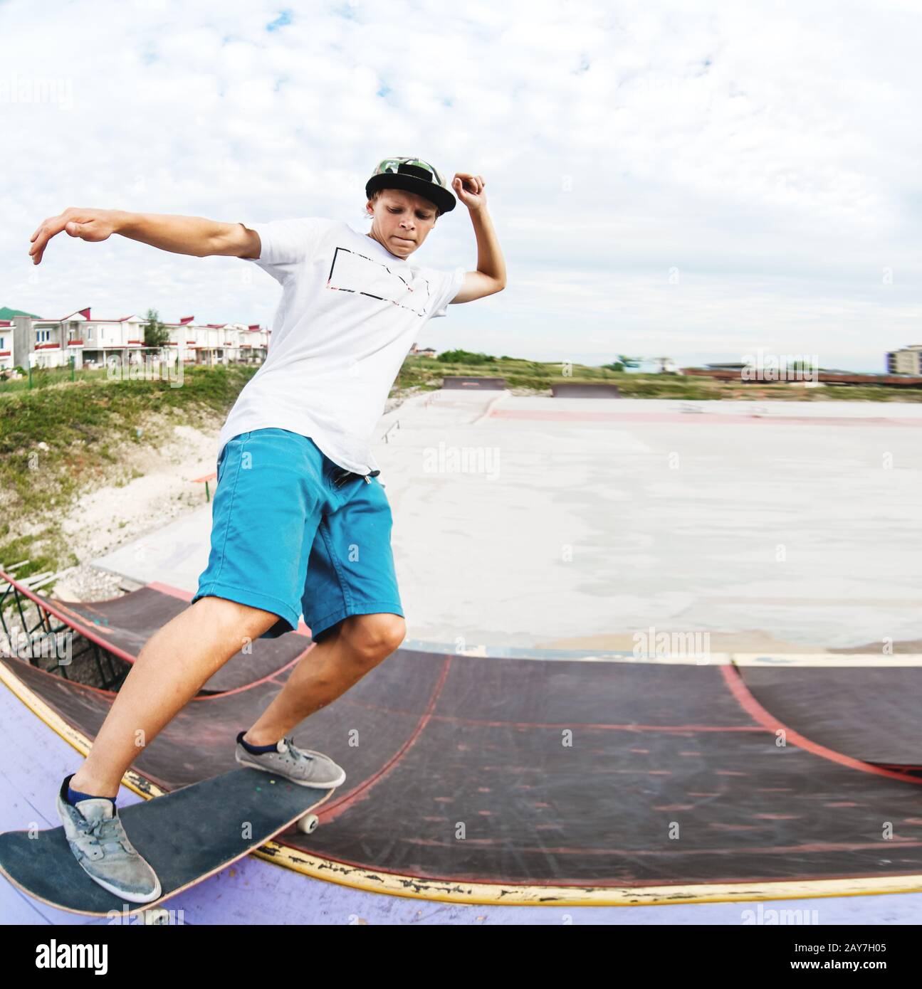 Teenager Skater hängen über eine Rampe auf einem Skateboard in einem Skatepark Stockfoto
