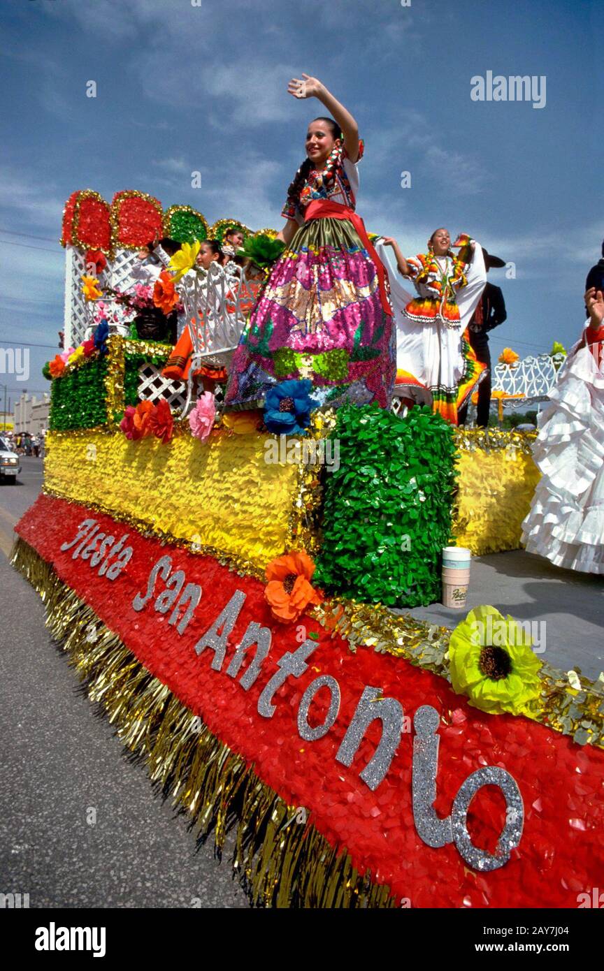 San Antonio, Texas: Hispanische Teenager in aufwendigen Kostümen reiten auf einem Festwagen während der Battle of the Flowers Parade, Teil der jährlichen Fiesta San Antonio Feier. ©Bob Daemmrich Stockfoto