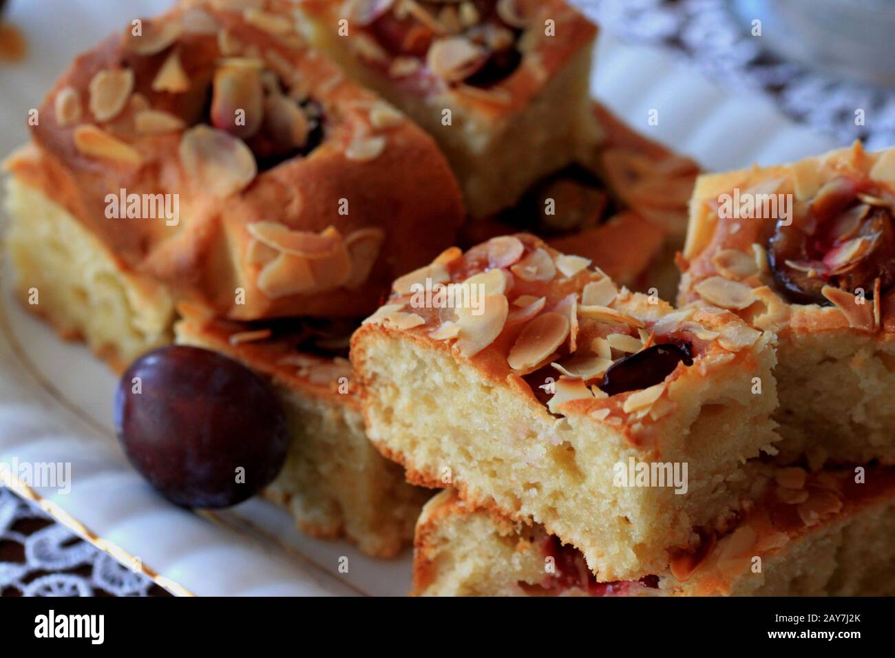 Kuchen mit Pflaumen und Mandelflocken. Hausgemachter Kuchen. Kuchen mit Obst. Ein köstliches und leichtes Dessert. Pflaumenkuchen. Schwammkuchen mit Früchten. Stockfoto