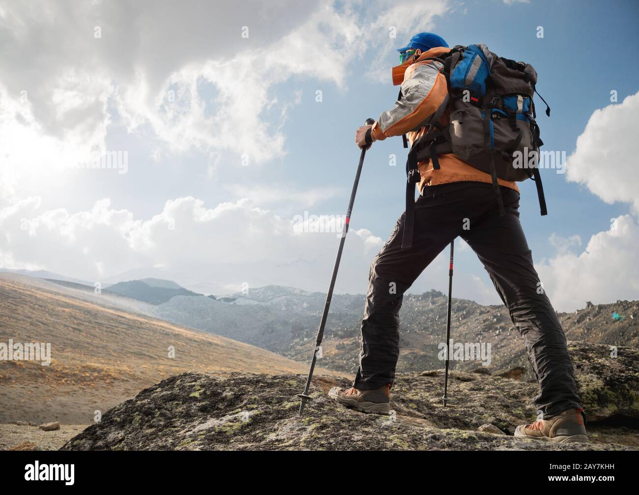 Ein einsamer Tourist genießt die Aussicht hoch in den Bergen, wo es kein Gras vom Dorf und Schnee gibt Stockfoto